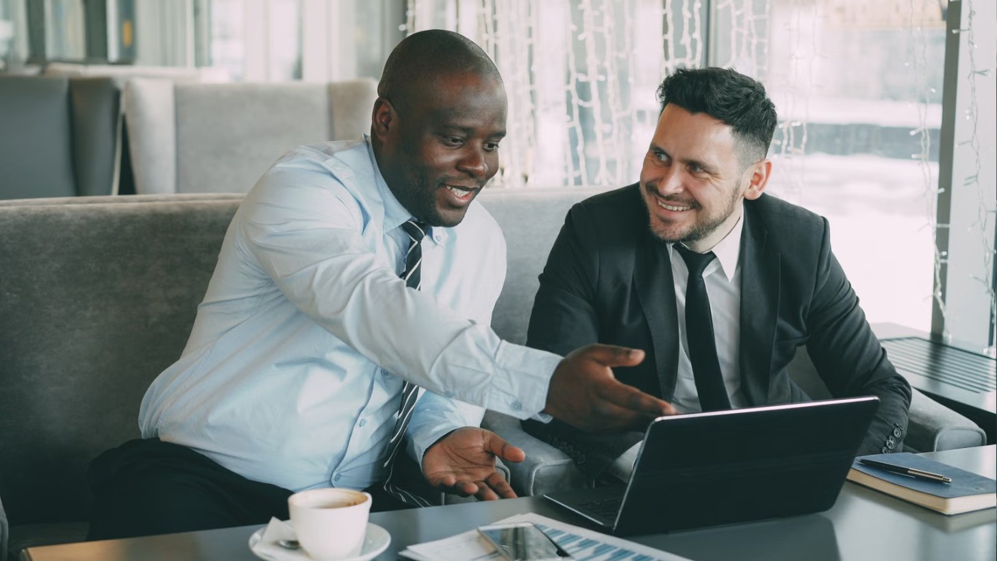 Two colleagues having a friendly conversation over a laptop