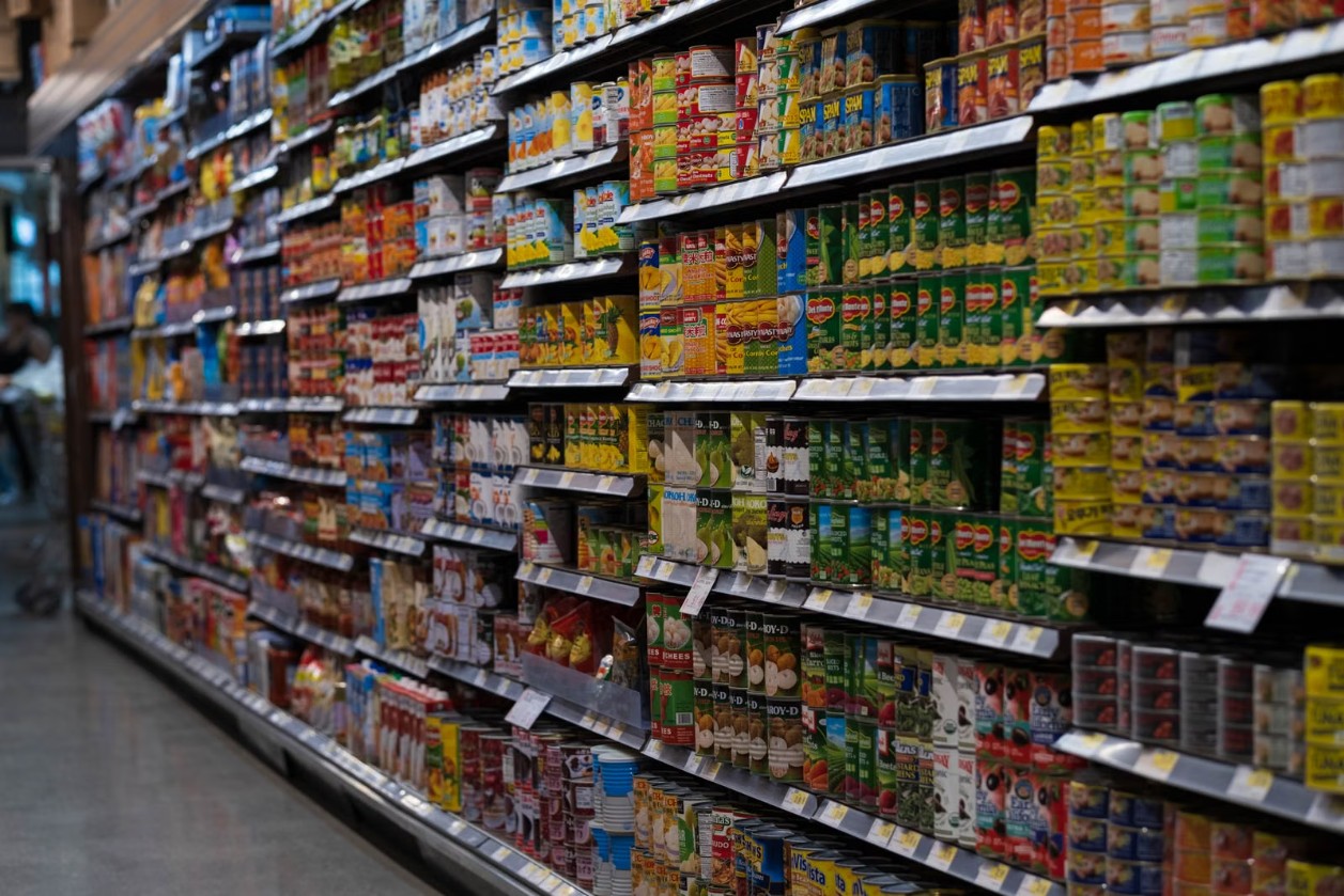 A fully stocked grocery store aisle of canned and packaged goods