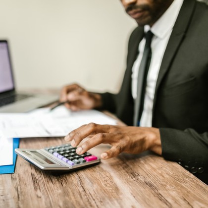 Finance professional reviewing figures with a calculator